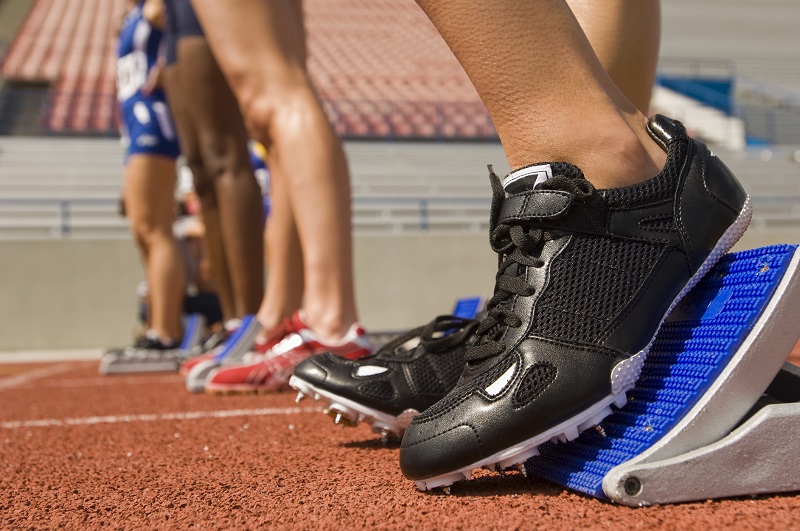 row of athletes with spikes runners on waiting to race